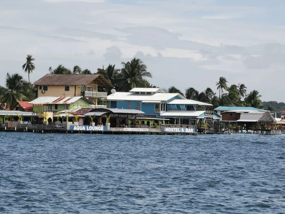 Edificaciones coloridas y palmeras frente al mar en Bocas del Toro
